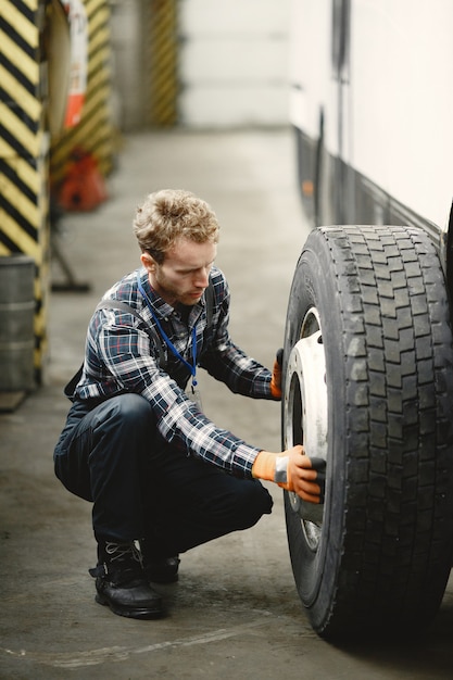 Free photo worker with a wheel. wheel replacement. man in uniform