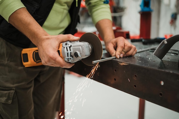 Worker working with a circular grinder on a metal with sparks