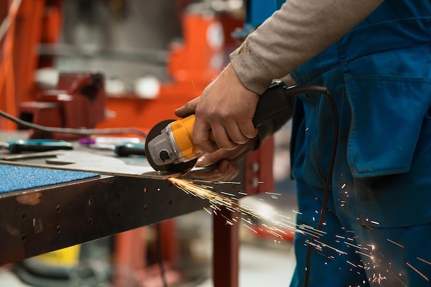 Worker working with a circular grinder on a metal with sparks