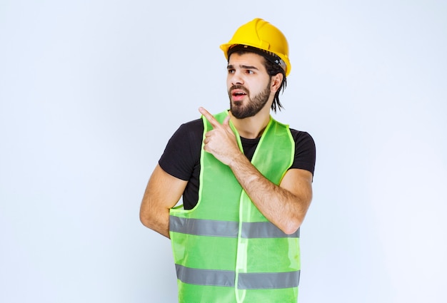 Worker in yellow helmet showing left side.