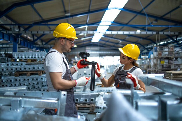 Workers checking parts manufactured in factory