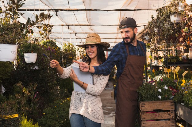 Workers pointing at plants in glasshouse