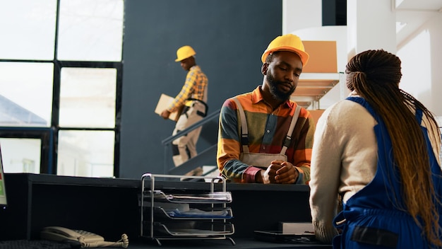 Free photo workers talking about order management at depot, planning manufacturing and stock shipment for retail store production. storehouse employees moving merchandise goods. handheld shot.