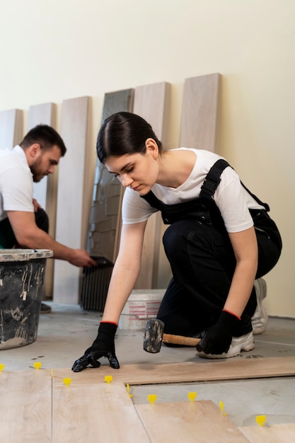 Workers tiling floor indoors