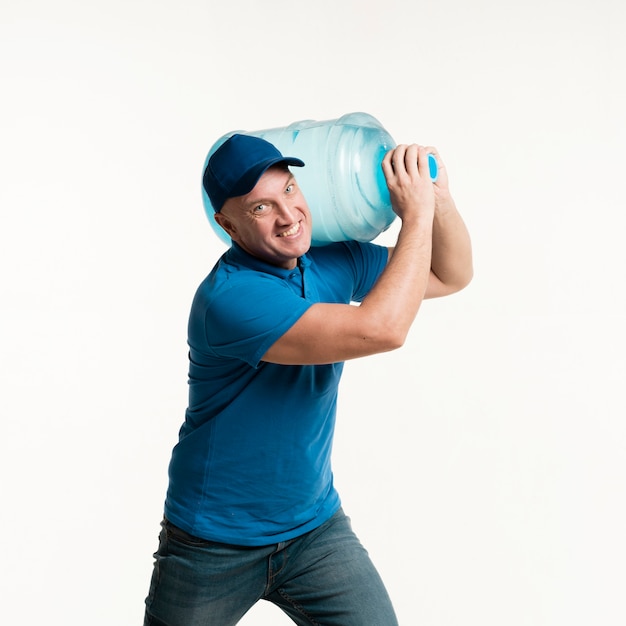 Working delivery man holding water bottle