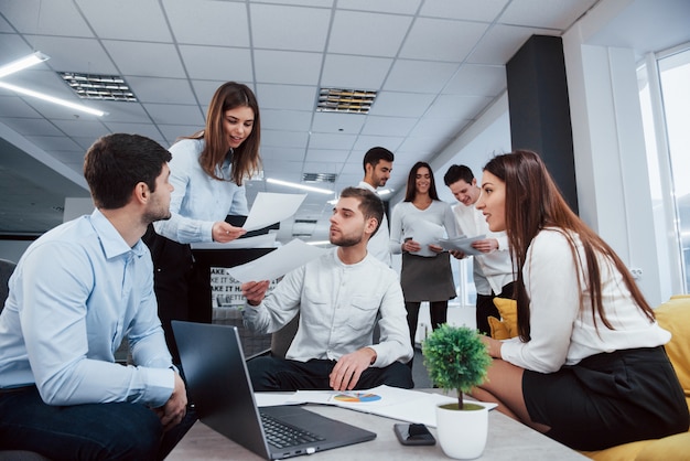 Foto gratuita atmosfera lavorativa ma divertente. il gruppo di giovani liberi professionisti nell'ufficio ha conversazione e sorridere