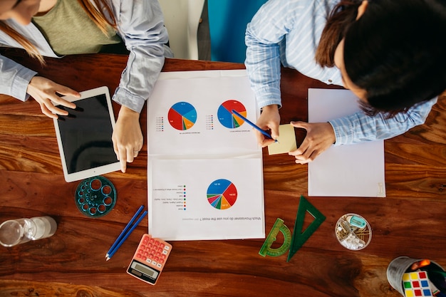 Foto gratuita ragazze che lavorano con le carte al tavolo