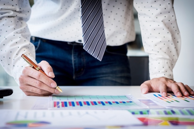 Working process startup. Businessman working at the wood table with new finance project. Modern notebook on table. Pen holding hand