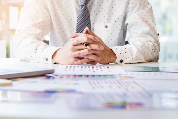 Foto gratuita avvio del processo di lavoro. uomo d'affari che lavora al tavolo di legno con il nuovo progetto di finanza. notebook moderno sul tavolo. punta di mano della penna