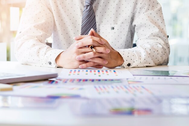 Working process startup. Businessman working at the wood table with new finance project. Modern notebook on table. Pen holding hand