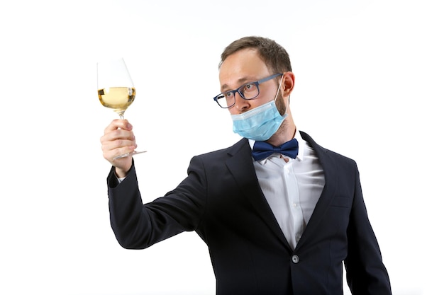 Free photo working in protective face mask portrait of male sommelier wine steward or bar worker in white and black suit isolated over white background copyspace for ad concept of professional occupation