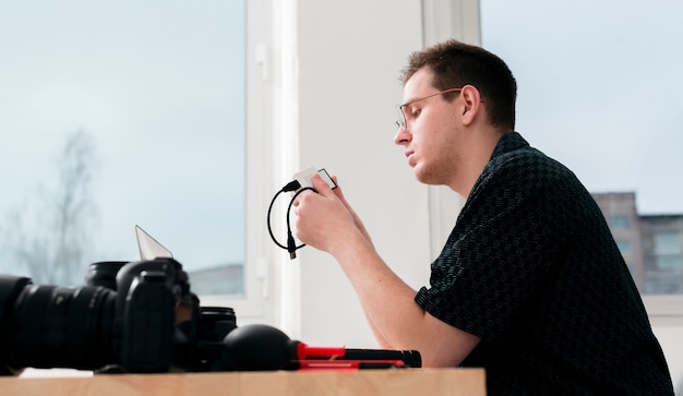 Foto gratuita lavoro laterale fotografo uomo e macchine fotografiche