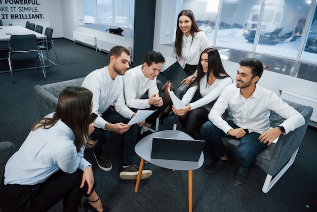 Working together in friendly atmosphere near table with silver colored laptop