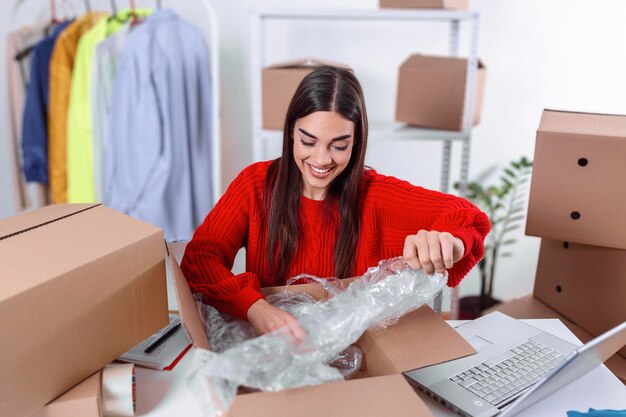 Working woman at online shop. she is wearing casual clothing and packaging goods for delivery. women, owener of small business packing product in boxes, preparing it for delivery
