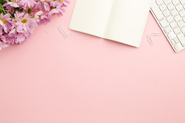 Working woman pink desk with empty notebook