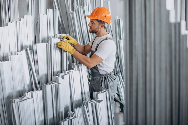 Workman at store house in orange helmet