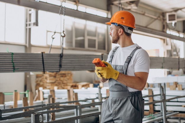 Workman at store house in orange helmet