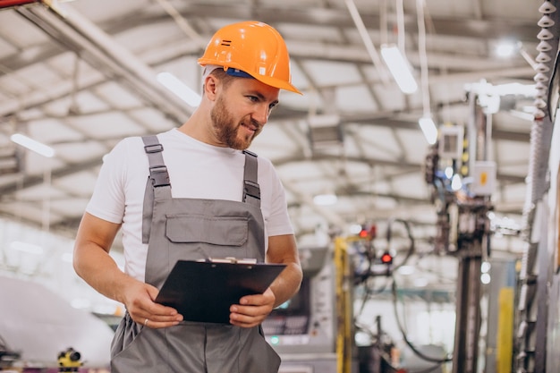 Workman at store house in orange helmet