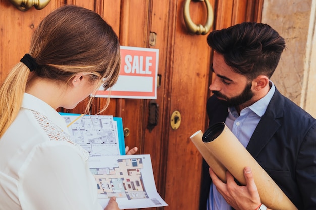 I compagni di lavoro guardano i piani della casa