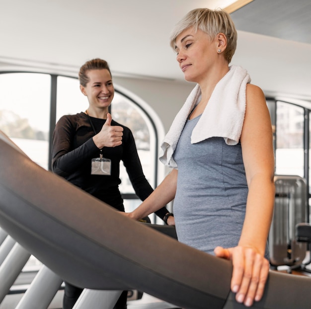 Workout program trainer and client standing on treadmill