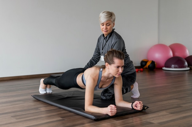 Workout with personal trainer doing low plank high view