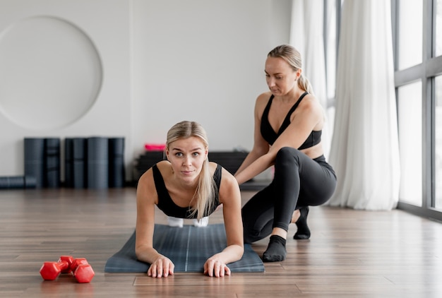 Workout with personal trainer doing planks