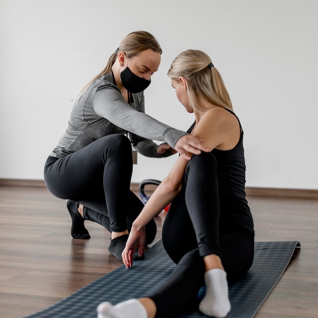 Workout with personal trainer wearing protection masks