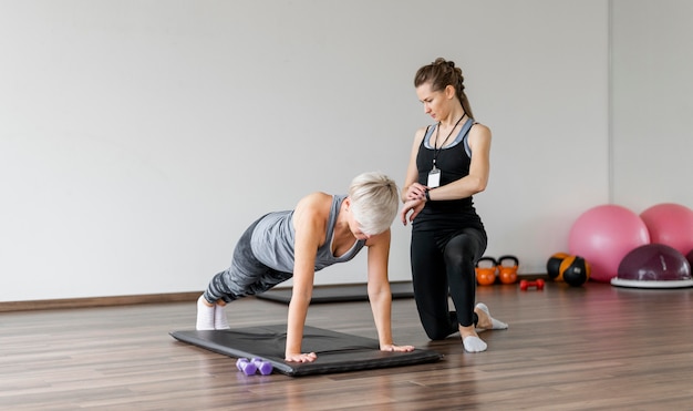 Workout with personal trainer on yoga mat