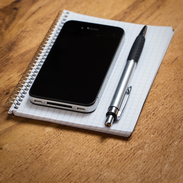 Workplace. Phone and notepad on the table