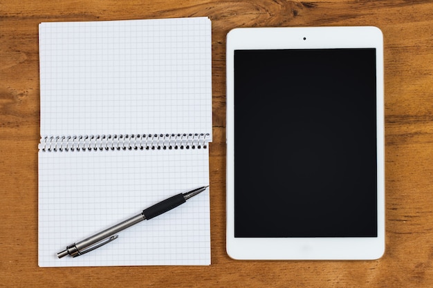 Workplace. Phone, tablet and notepad on the table