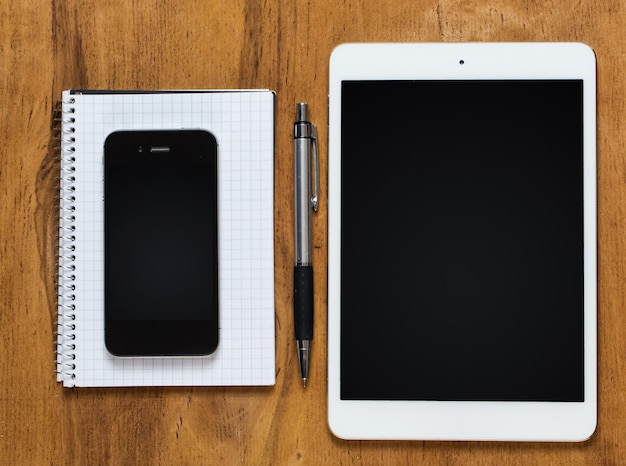 Workplace. Phone, tablet and notepad on the table