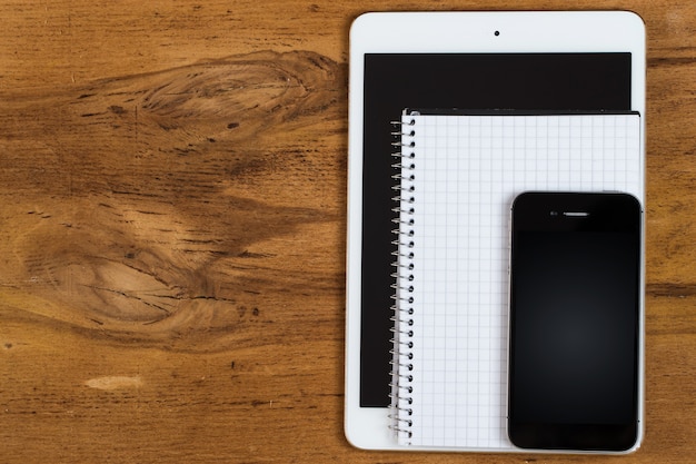 Workplace. Phone, tablet and notepad on the table