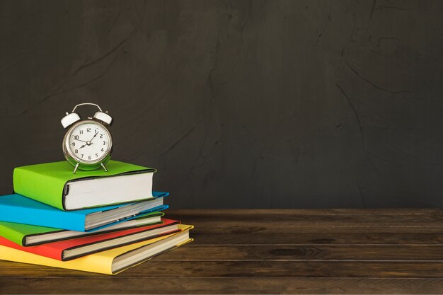 Workplace with books pile and alarm clocks