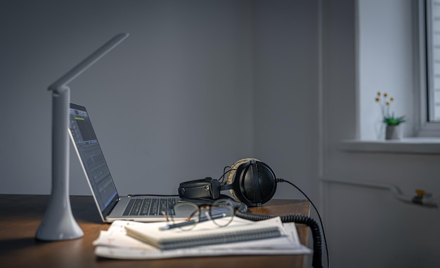 Workplace with headphones and laptop in the evening copy space