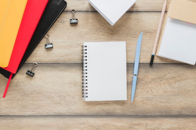 Workplace with notebook placed near stationery on wooden table