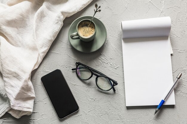 Workplace with smartphone and blank notepad