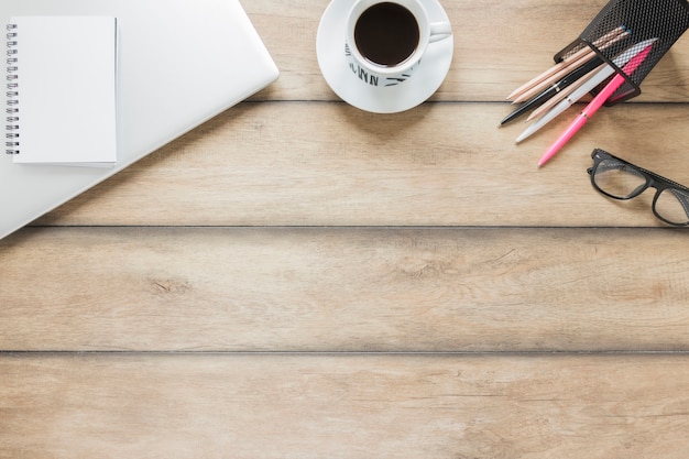 Workplace with stationery, laptop and cup of coffee