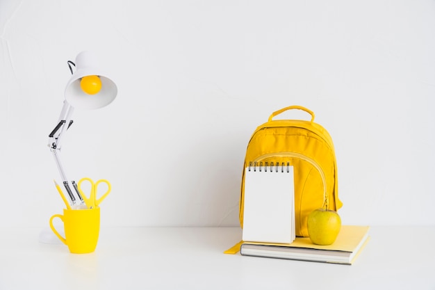 Workplace with yellow backpack and apple