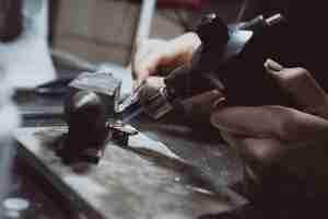 Free photo in the workshop, a woman jeweler is busy soldering jewelry