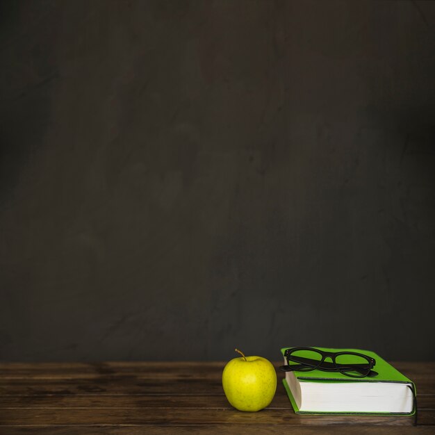 Workspace with book glasses and apple