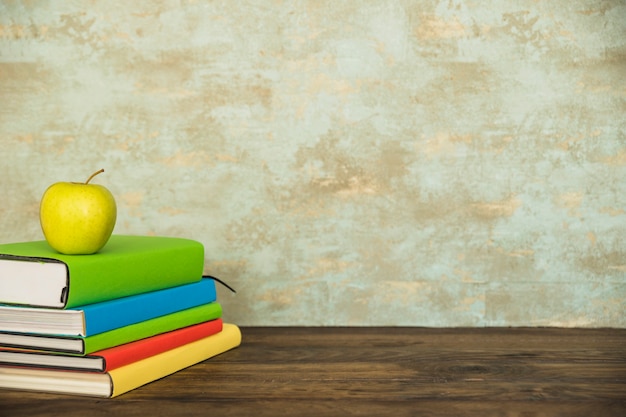 Workspace with books and green apple