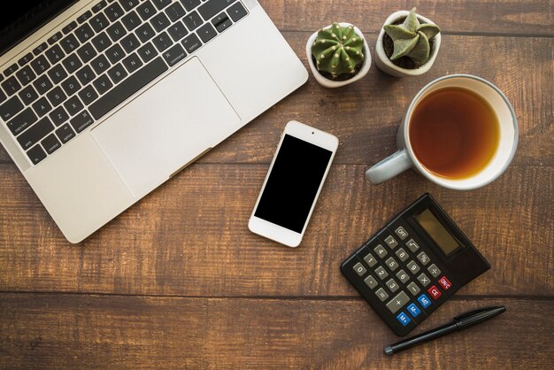 Workspace with laptop and smartphone near tea cup