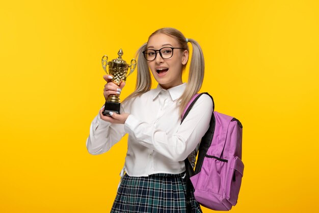 World book day happy school girl holding a price in glasses