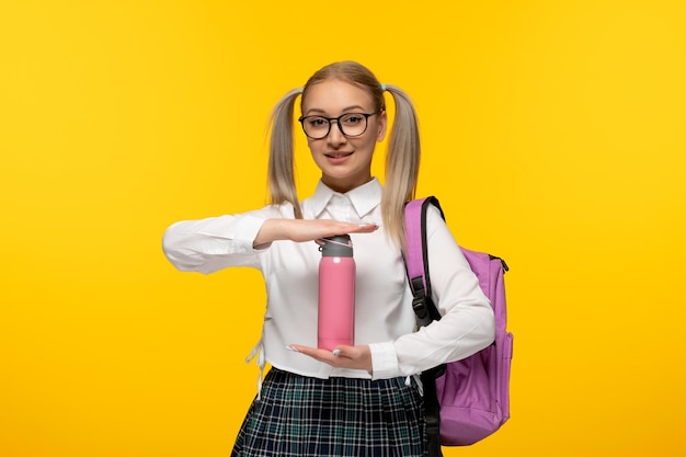 World book day schoolgirl with ponytails holding a pink flask