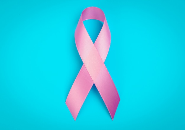 World cancer day : Breast Cancer Awareness Ribbon on blue Backgr
