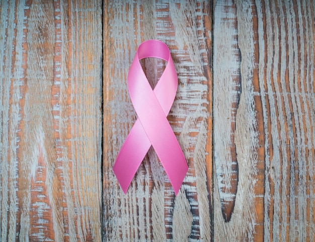 World cancer day : Breast Cancer Awareness Ribbon on wood Backgr