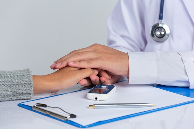 Foto gratuita giornata mondiale del diabete; medico che tiene la mano del paziente