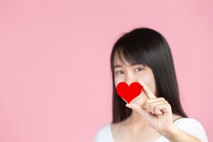 world diabetes day; woman holding red heart on pink wall