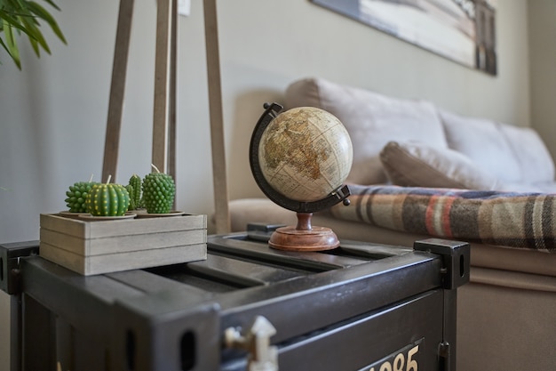 Free photo world globe figure on the shelf next to a plant by the bed