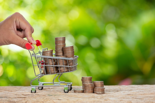 Free photo world habitat day,close up picture of a hand pushing little cart which full of coins